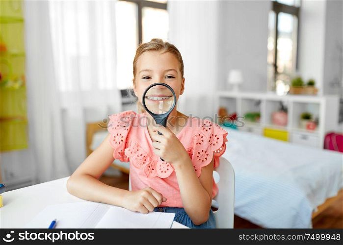 education, exploration and learning concept - student girl with magnifier and notebook showing her teeth at home. student girl with magnifier and notebook at home