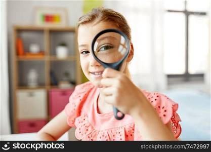 education, exploration and vision concept - student girl looking through magnifier at home. student girl looking through magnifier at home