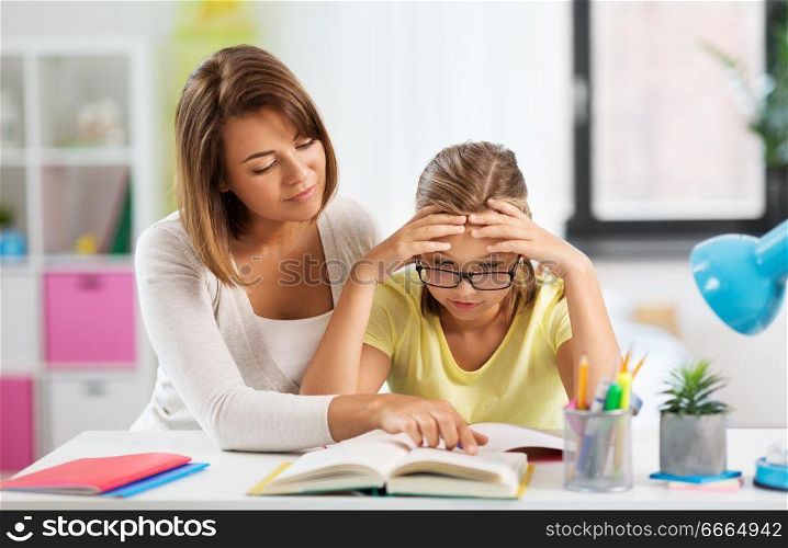 education, family and learning concept - mother helping daughter with difficult homework task at home. mother helping daughter with difficult homework