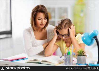 education, family and learning concept - mother helping daughter with difficult homework task at home. mother helping daughter with difficult homework