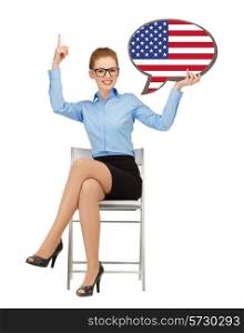 education, foreign language, english, people and communication concept - smiling woman holding text bubble of american flag and pointing finger up