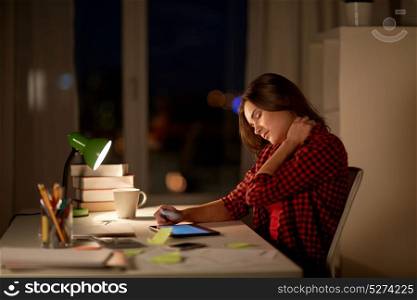education, freelance, overwork and people concept - tired woman or student girl with tablet pc computer touching neck at night home. tired student or woman touching neck at night home