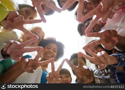 education, friendship, gesture, victory and people concept - group of happy international students or friends standing in circle and showing peace or v sign