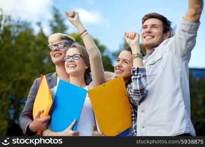 education, friendship, success and teenage concept - group of happy students showing triumph gesture at campus or park