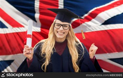 education, gesture and people concept - happy female student in mortar board and bachelor gown with diploma celebrating successful graduation over british flag background. happy student with diploma over british flag