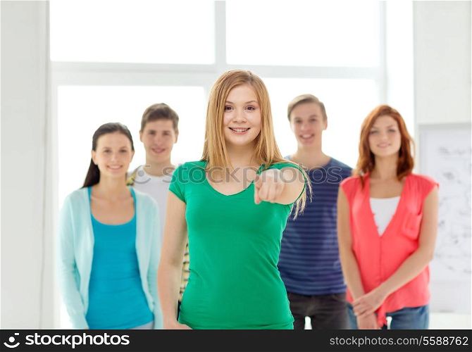 education, gesture and school concept - group of smiling students with teenage girl in front pointing at you