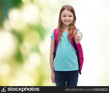 education, gesture and school concept - happy and smiling little girl with school bag showing thumbs up