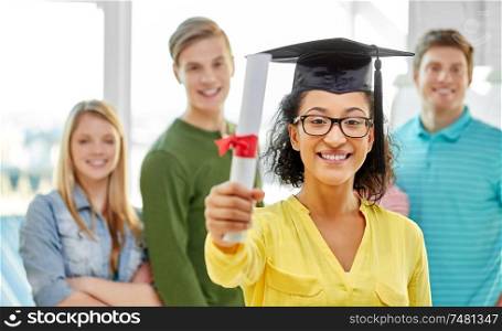 education, graduation and people concept - graduate student girl in mortar board with diploma and group of classmates. graduate student girl in mortar board with diploma