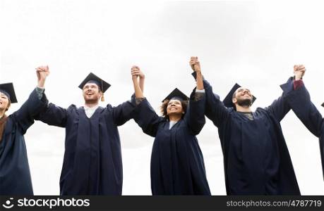 education, graduation and people concept - group of happy international students in mortar boards and bachelor gowns celebrating success