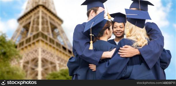 education, graduation and people concept - group of happy international students in mortar boards and bachelor gowns hugging over eiffel tower background