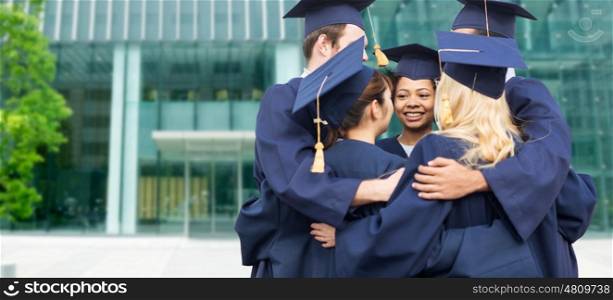 education, graduation and people concept - group of happy international students in mortar boards and bachelor gowns hugging over university building background
