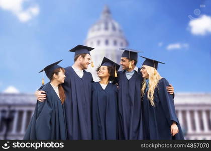 education, graduation and people concept - group of happy international students in mortar boards and bachelor gowns over american white house background