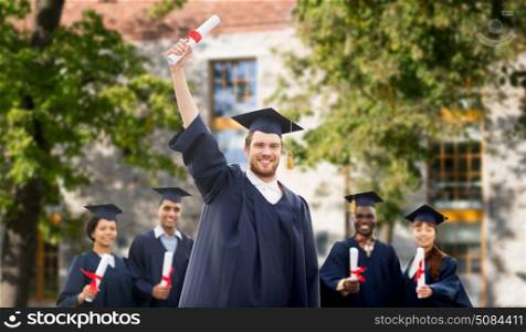 education, graduation and people concept - group of happy international students in mortar boards and bachelor gowns with diplomas over campus building background. happy students in mortar boards with diplomas. happy students in mortar boards with diplomas
