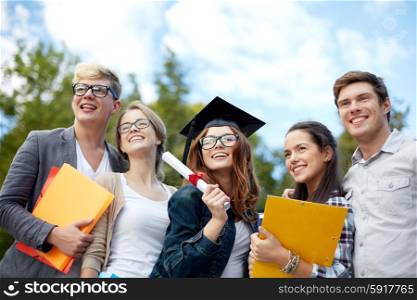 education, graduation and people concept - group of smiling students in mortarboard with diploma and school folders
