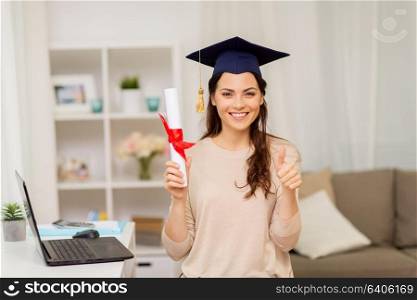 education, graduation and people concept - happy female student with diploma at home showing thumbs up. student with diploma at home showing thumbs up