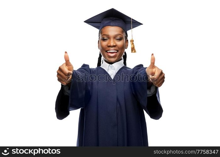 education, graduation and people concept - happy graduate student woman in mortarboard and bachelor gown showing thumbs up. happy female graduate student in mortarboard