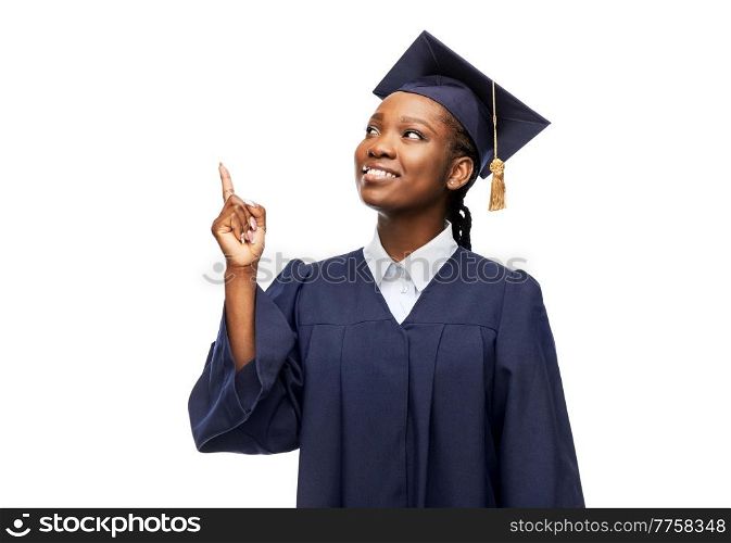 education, graduation and people concept - happy graduate student woman in mortarboard and bachelor gown pointing finger up over white background. happy female graduate student in mortarboard