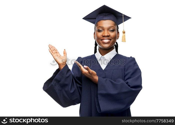 education, graduation and people concept - happy graduate student woman in mortarboard and bachelor gown showing something imaginary over white background. happy female graduate student in mortarboard