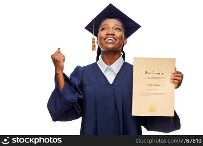 education, graduation and people concept - happy graduate student woman in mortarboard and bachelor gown showing diploma of university and making winning gesture over white background. happy female graduate student with diploma