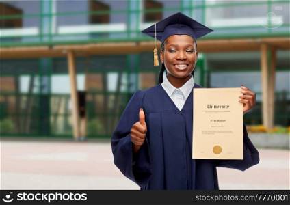 education, graduation and people concept - happy graduate student woman in mortarboard and bachelor gown with diploma of university showing thumbs up over school building on background. graduate student with diploma showing thumbs up