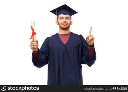 education, graduation and people concept - happy male graduate student in mortar board and bachelor gown with diploma pointing finger up over white background. male graduate student in mortar board with diploma