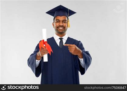 education, graduation and people concept - happy smiling indian male graduate student in mortar board and bachelor gown with diploma over grey background. male graduate student in mortar board with diploma