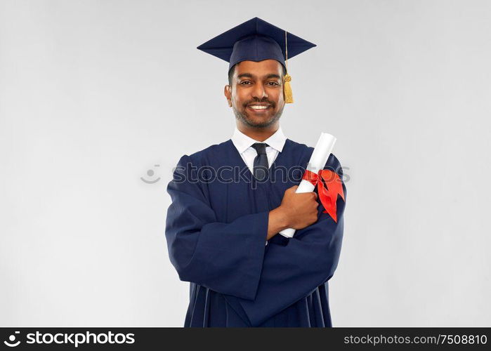 education, graduation and people concept - happy smiling indian male graduate student in mortar board and bachelor gown with diploma over grey background. male graduate student in mortar board with diploma