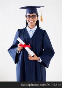education, graduation and people concept - happy student woman in mortarboard and bachelor gown with diploma. happy bachelor woman in mortarboard with diplomas