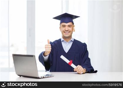 education, graduation, business, technology and people concept - happy adult student in mortarboard with diploma and laptop computer showing thumbs up home or office