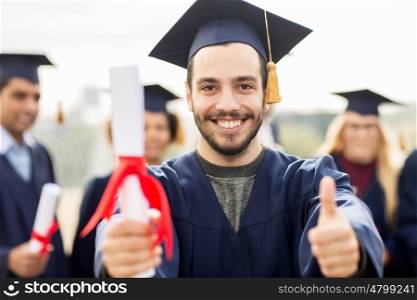 education, graduation, gesture and people concept - close up of happy international students in mortar boards and bachelor gowns with diplomas showing thumbs up