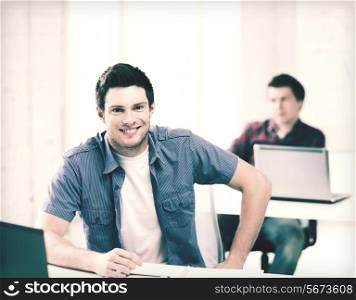 education - group of smiling students with laptops at school