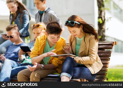 education, high school and people concept - group of happy teenage students with with tablet pc computers at campus yard