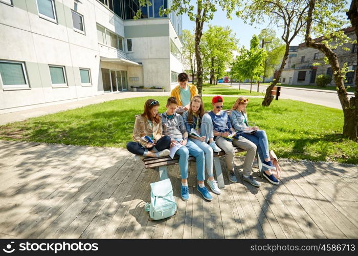 education, high school and people concept - group of happy teenage students with notebooks learning at campus yard