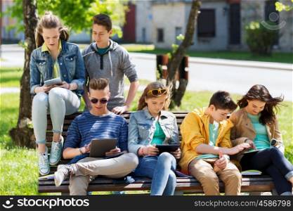 education, high school and people concept - group of happy teenage students with with tablet pc computers at campus yard