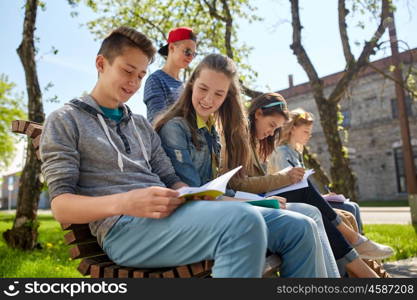 education, high school and people concept - group of happy teenage students with notebooks learning at campus yard