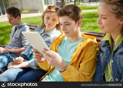 education, high school and people concept - group of happy teenage students with tablet pc computers at campus yard