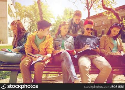 education, high school and people concept - group of happy teenage students with notebooks learning at campus yard. group of students with notebooks at school yard