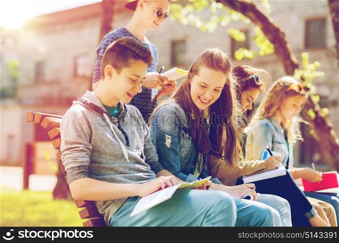 education, high school and people concept - group of happy teenage students with notebooks learning at campus yard. group of students with notebooks at school yard
