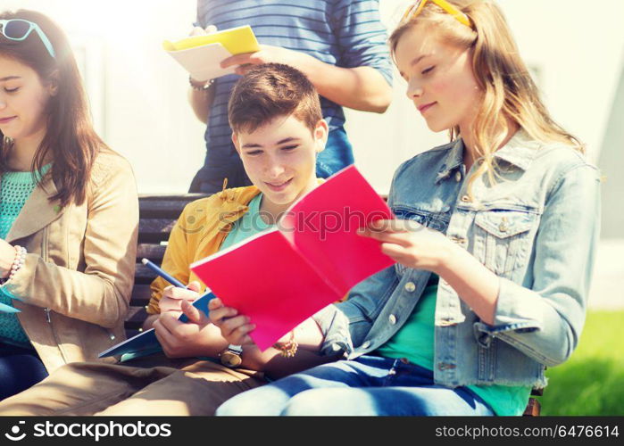 education, high school and people concept - group of happy teenage students with notebooks learning at campus yard. group of students with notebooks at school yard. group of students with notebooks at school yard