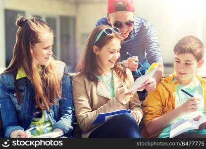 education, high school and people concept - group of happy teenage students with notebooks learning at campus yard. group of students with notebooks at school yard. group of students with notebooks at school yard