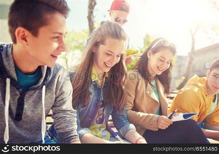 education, high school and people concept - group of happy teenage students with notebooks learning at campus yard. group of students with notebooks at school yard. group of students with notebooks at school yard