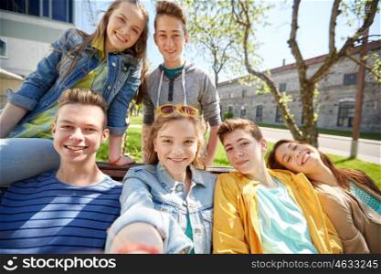 education, high school and people concept - group of happy teenage students or friends taking selfie