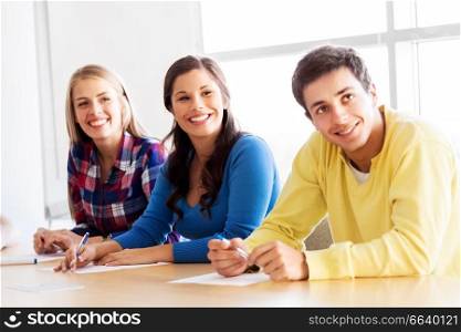 education, high school and people concept - group of teenage smiling students in lecture hall or classroom. group of teenage students at school classroom