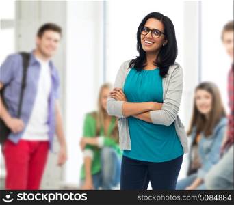 education, high school and people concept - happy smiling young indian woman or teacher in glasses over classroom background. happy smiling young indian woman in glasses. happy smiling young indian woman in glasses