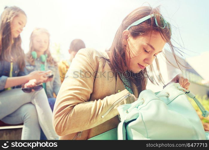 education, high school and people concept - happy teenage student girl looking for something in her backpack outdoors. high school student girl with backpack outdoors. high school student girl with backpack outdoors