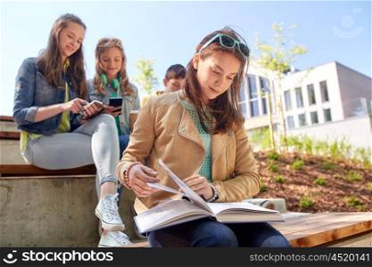 education, high school and people concept - high school student girl reading book outdoors