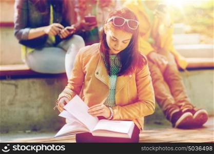 education, high school and people concept - high school student girl reading book outdoors. high school student girl reading book outdoors