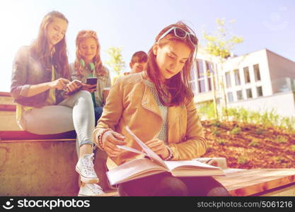 education, high school and people concept - high school student girl reading book outdoors. high school student girl reading book outdoors