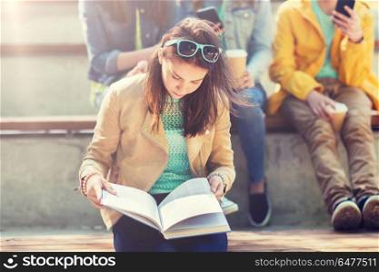 education, high school and people concept - high school student girl reading book outdoors. high school student girl reading book outdoors. high school student girl reading book outdoors