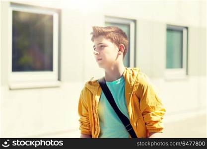 education, high school and people concept - teenage student boy walking outdoors. teenage student boy walking outdoors. teenage student boy walking outdoors